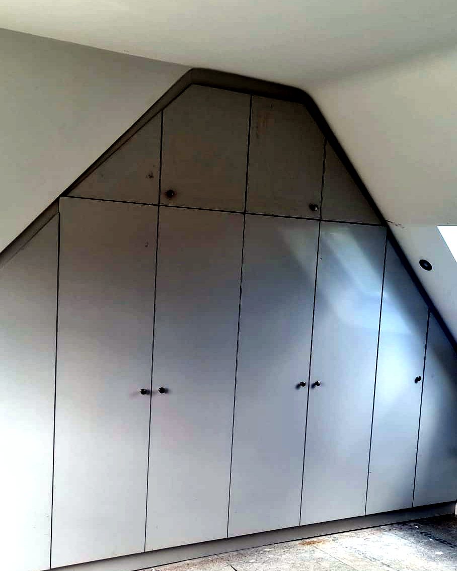 Bespoke fitted wardrobe built into a sloped loft eaves space, installed by BFK