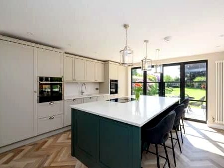 Bespoke Shaker kitchen with deep green island, quartz worktop and herringbone flooring, installed by BFK